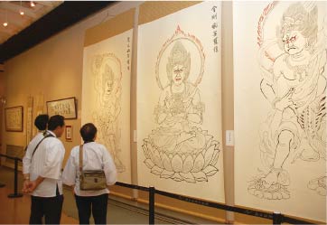 静慈圓の仏画作品に見入る入場者。多くがその迫力に圧倒されていた。